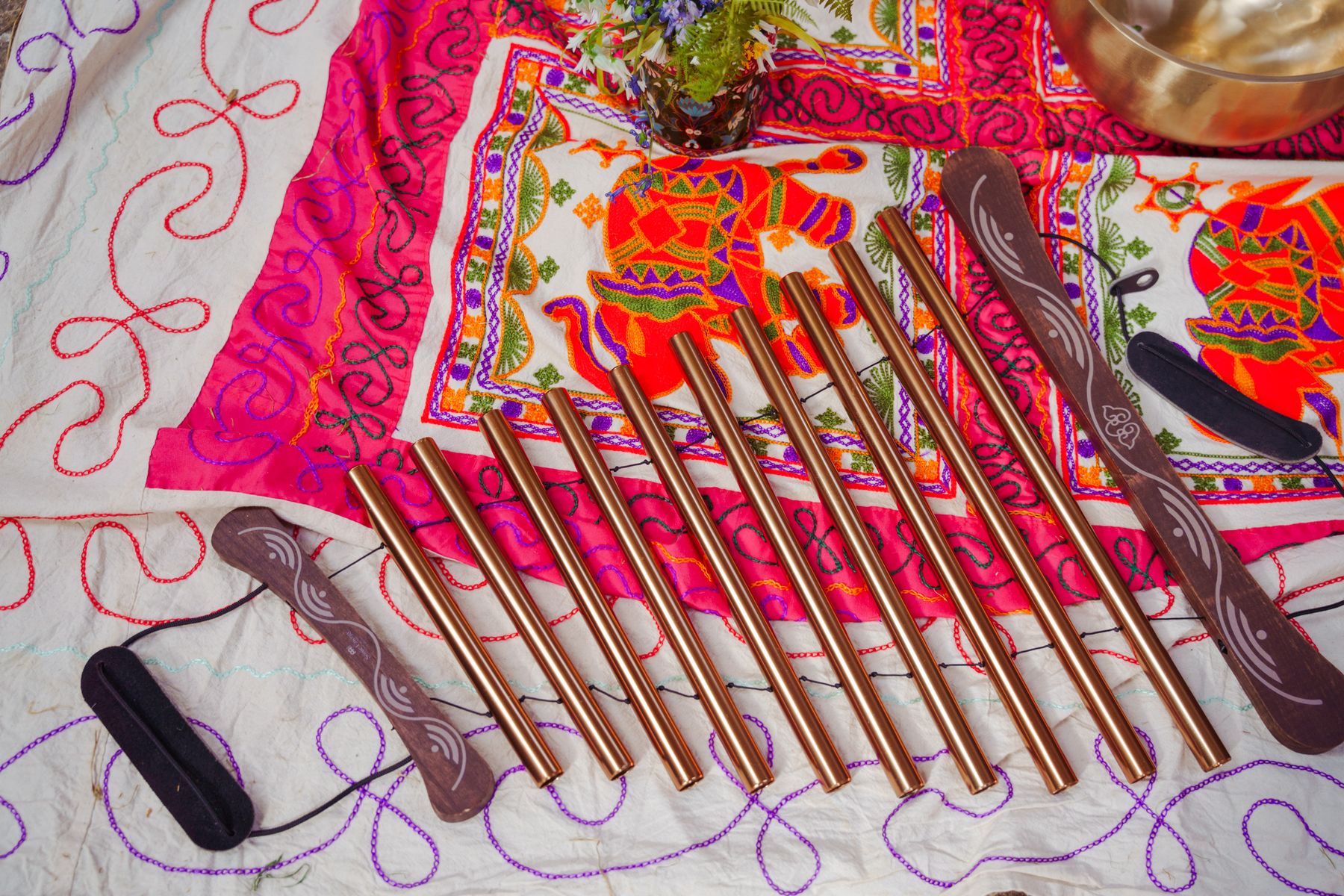 A row of chimes laid on embroidered cloth