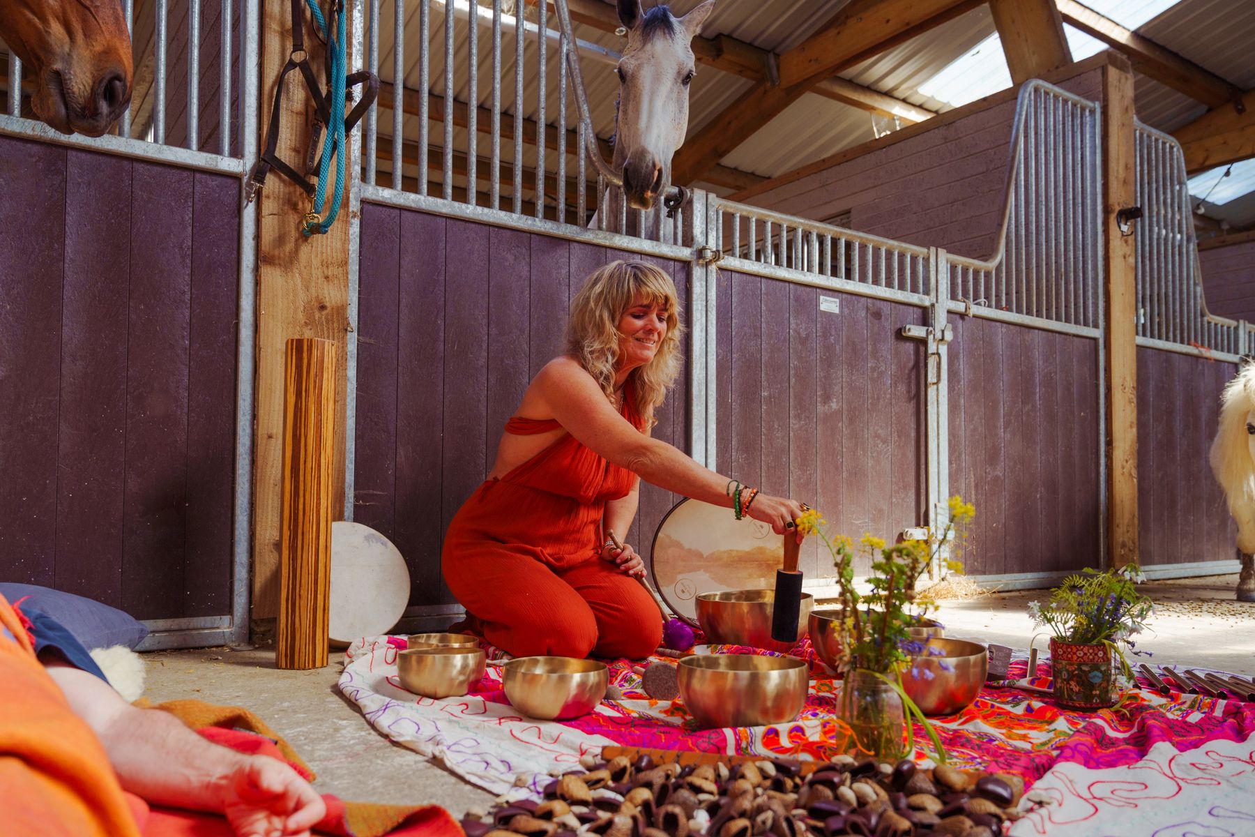 A sound bath held in the stable barn, singing bowls set out on the floor